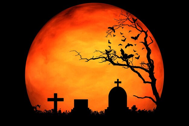 Foto vista en bajo ángulo de las lápidas en silueta y la cruz contra la luna naranja