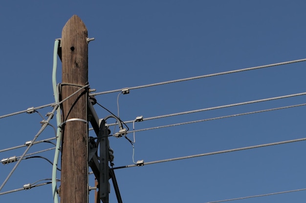 Foto vista en bajo ángulo de las líneas eléctricas contra un cielo azul claro