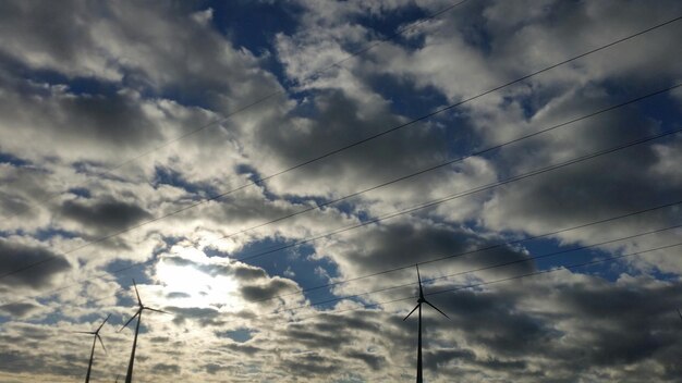 Vista en bajo ángulo de las líneas eléctricas contra un cielo nublado