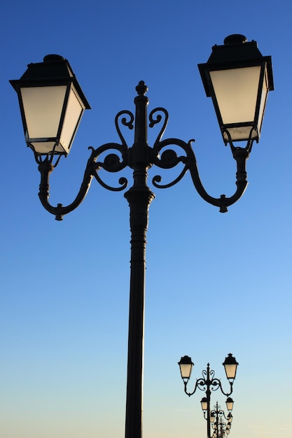 Vista de ángulo bajo de las luces de la calle contra el cielo azul