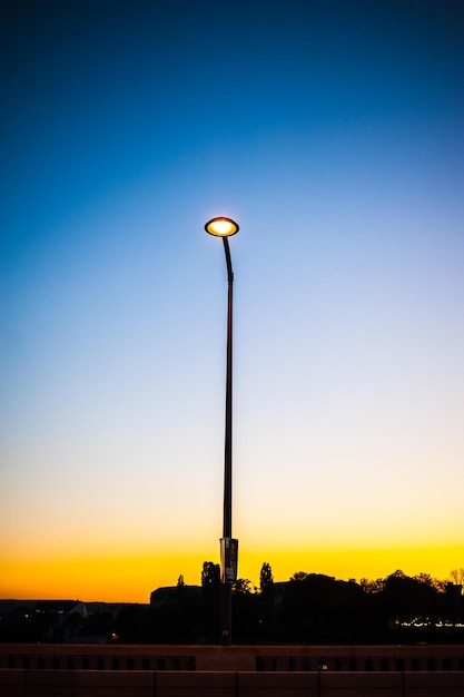 Vista de ángulo bajo de la luz de la calle contra el cielo al atardecer