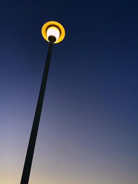 Vista de bajo ángulo de la luz de la calle contra un cielo azul claro