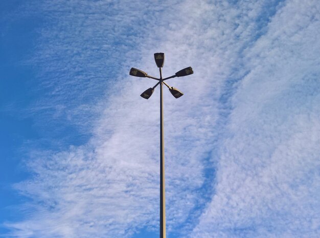 Vista de ángulo bajo de la luz de la calle contra el cielo azul