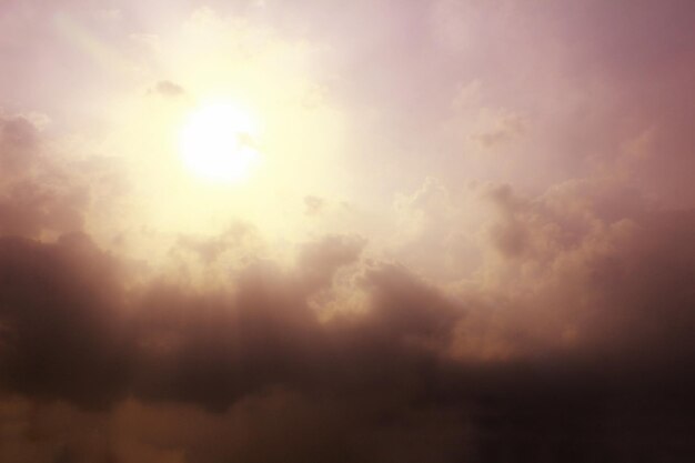 Foto vista de ángulo bajo de la luz solar que fluye a través de las nubes durante la puesta de sol