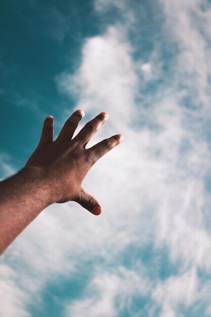 Vista de ángulo bajo de la mano contra el cielo