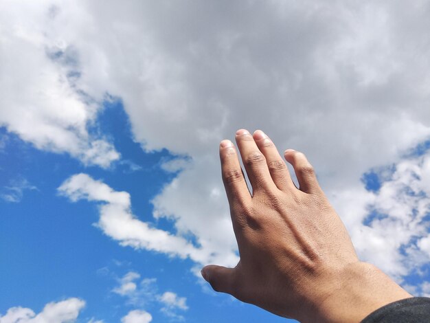 Foto vista de ángulo bajo de la mano humana contra el cielo