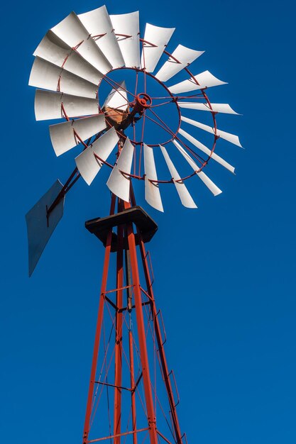 Foto vista de ángulo bajo del molino de viento tradicional contra un cielo azul claro