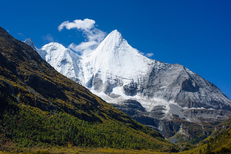 Foto vista de bajo ángulo de la montaña cubierta de nieve contra el cielo azul