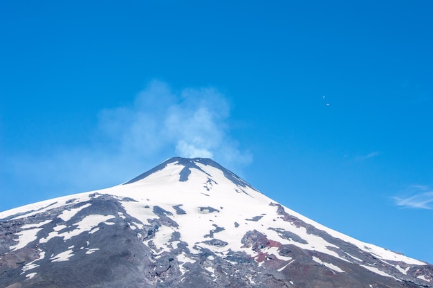 Vista de bajo ángulo de la montaña cubierta de nieve contra el cielo azul