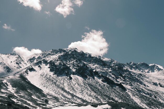 Foto vista en bajo ángulo de las montañas cubiertas de nieve contra el cielo