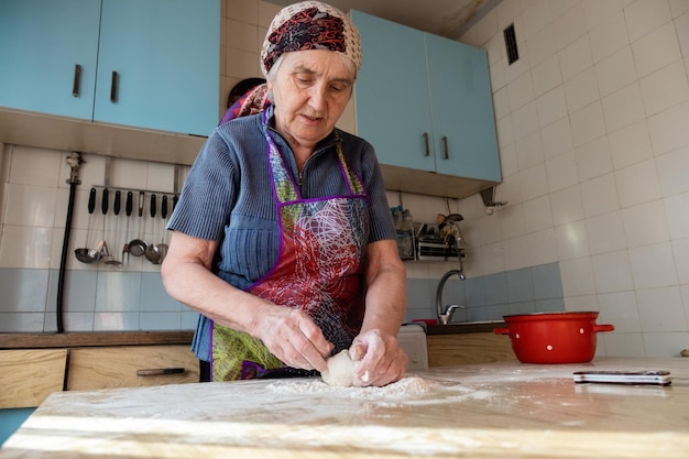 Foto vista de ángulo bajo de una mujer amassando masa en la mesa en casa