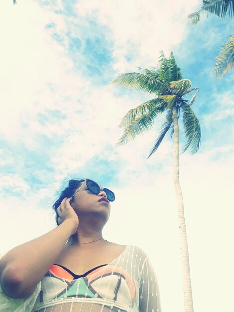 Foto vista de ángulo bajo de una mujer con gafas de sol contra el cielo