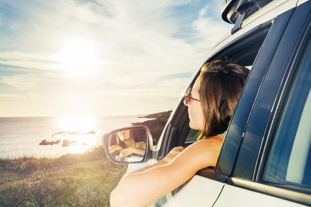 Vista de ángulo bajo de una mujer joven en un coche