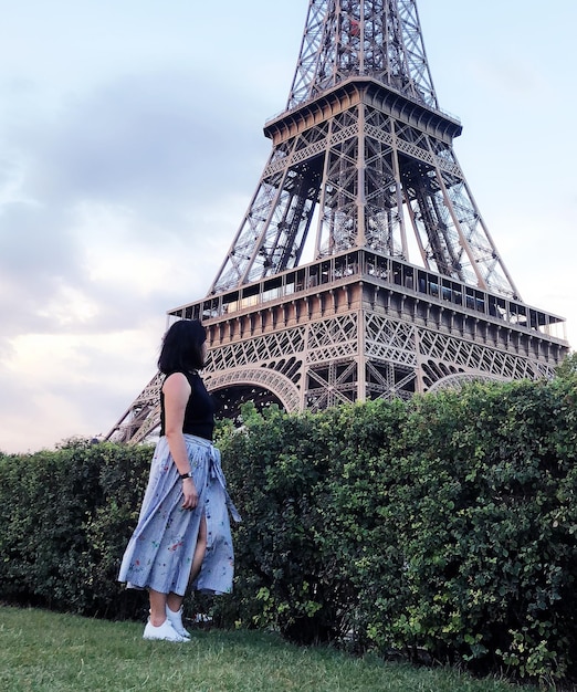 Vista en bajo ángulo de una mujer mirando la Torre Eiffel