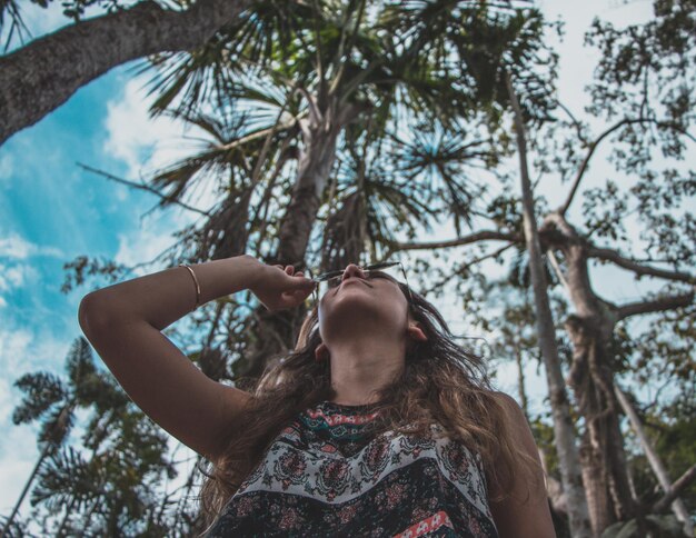 Foto vista de bajo ángulo de una mujer de pie contra los árboles