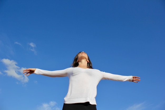 Vista de ángulo bajo de una mujer de pie contra el cielo