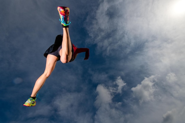 Foto vista de ángulo bajo de una mujer saltando contra el cielo