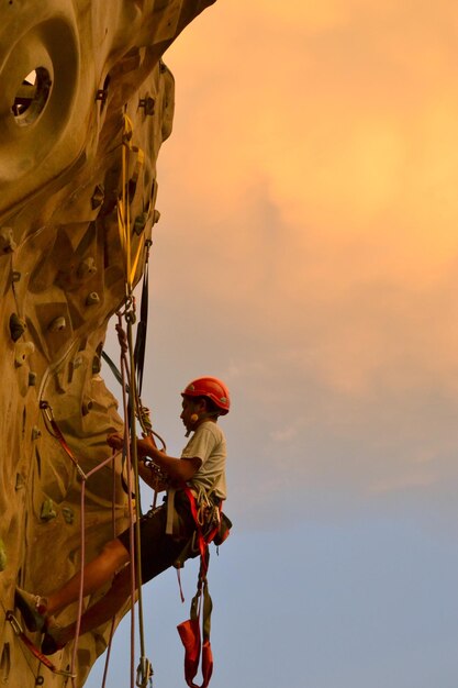 Foto vista en bajo ángulo de la pared de escalada del hombre