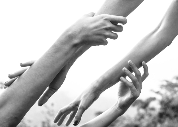 Foto vista de ángulo bajo de una pareja tomándose de la mano contra el cielo