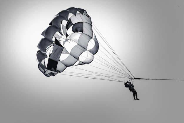 Vista de bajo ángulo de una persona en parapente en un cielo despejado en un día soleado