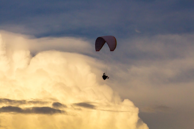 Vista en bajo ángulo de una persona en parapente contra el cielo