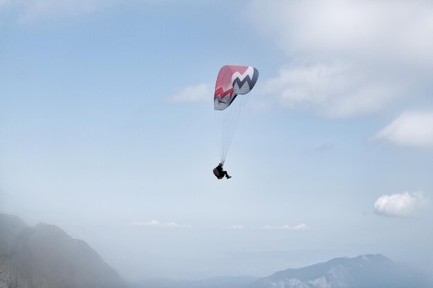Vista en bajo ángulo de una persona en parapente contra el cielo