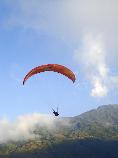 Vista en bajo ángulo de una persona en parapente contra el cielo