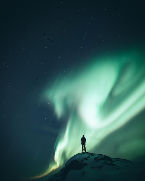Vista de ángulo bajo de una persona de pie contra el cielo por la noche