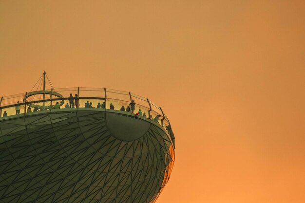 Foto vista de bajo ángulo de personas de pie en el punto de observación durante la puesta del sol