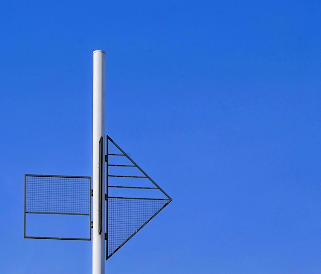Foto vista de ángulo bajo del poste contra el edificio contra el cielo azul claro