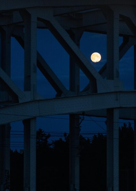 Foto vista de ángulo bajo del puente iluminado contra el cielo por la noche