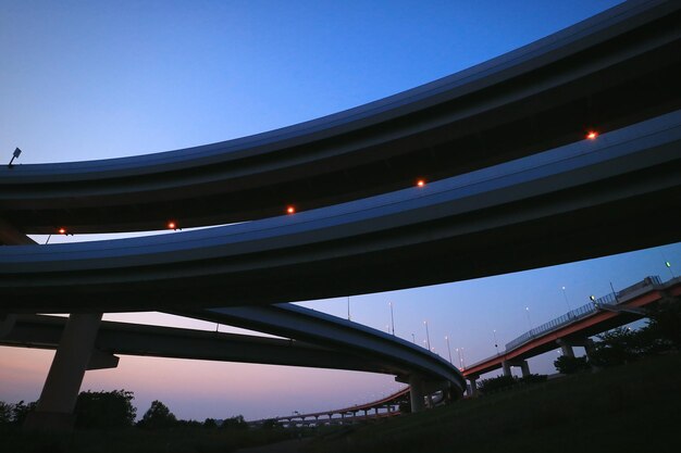 Vista de ángulo bajo del puente iluminado contra el cielo por la noche