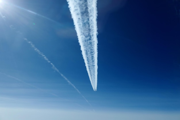 Vista de ángulo bajo del rastro de vapor en el cielo azul