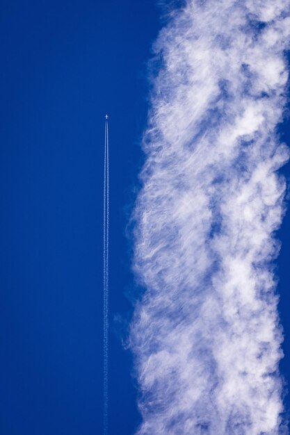 Vista de ángulo bajo del rastro de vapor contra el cielo azul