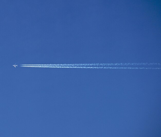 Foto vista de ángulo bajo del rastro de vapor contra el cielo azul