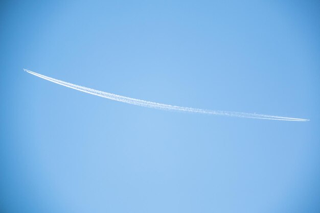 Foto vista de ángulo bajo del rastro de vapor contra el cielo azul