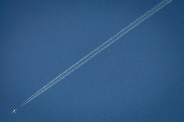 Foto vista de bajo ángulo de rastros de vapor en el cielo azul