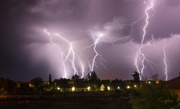Foto vista de ángulo bajo de relámpagos sobre las casas al anochecer