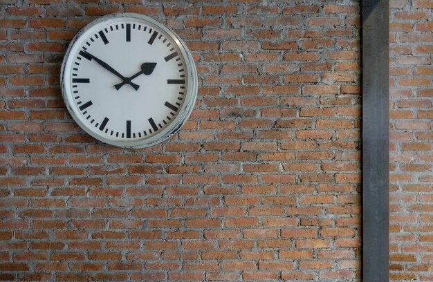 Foto vista en bajo ángulo del reloj en la pared de ladrillo