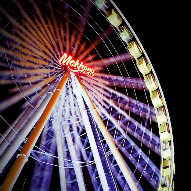 Foto vista de ángulo bajo de la rueda gigante iluminada por la noche