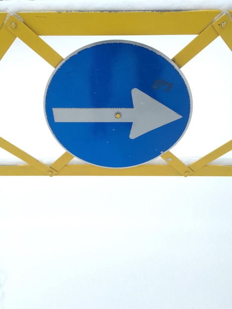 Foto vista de ángulo bajo del signo de flecha en la barandilla metálica