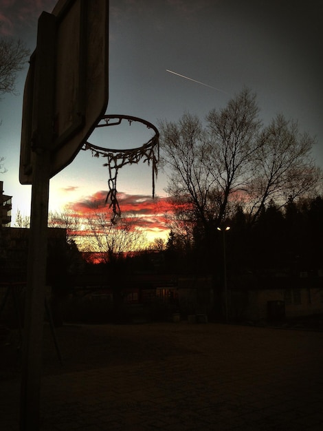 Foto vista de ángulo bajo de la silueta del aro de baloncesto durante la puesta de sol