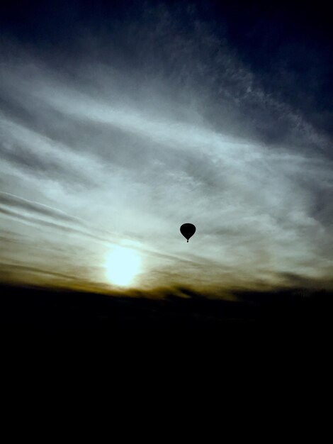 Foto vista de bajo ángulo de la silueta del globo de aire caliente volando contra el cielo