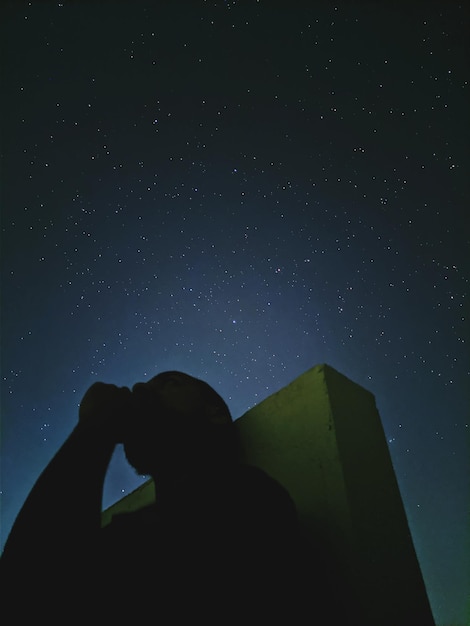 Foto vista de bajo ángulo de la silueta del hombre contra el cielo por la noche