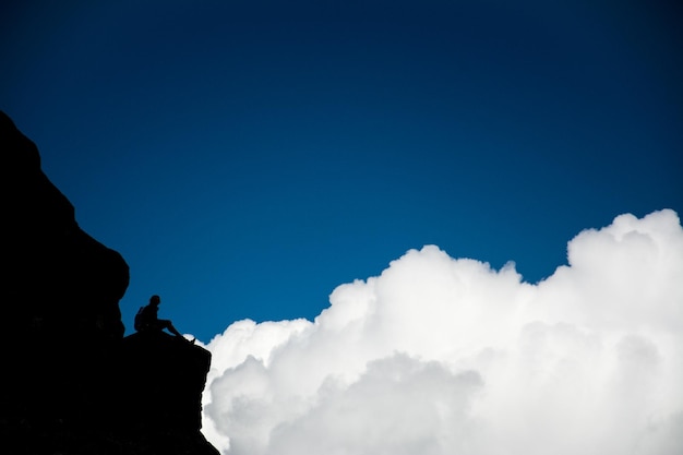 Foto vista de bajo ángulo de la silueta del hombre contra el cielo nublado