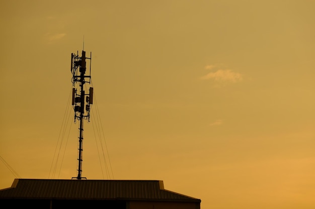 Vista en bajo ángulo de la silueta de la torre de comunicaciones contra el cielo durante la puesta de sol