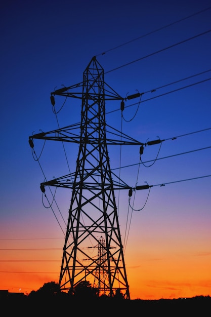 Foto vista de ángulo bajo de la silueta de la torre de electricidad contra el cielo al atardecer