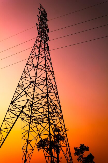 Foto vista de ángulo bajo de la silueta de la torre de electricidad contra el cielo dramático