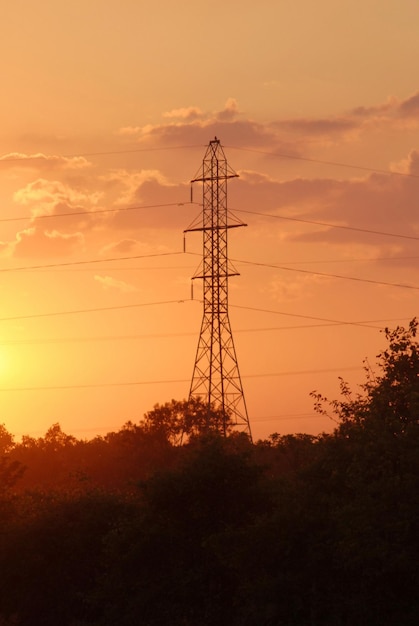 Foto vista de ángulo bajo de la silueta de la torre de electricidad contra el cielo durante la puesta del sol