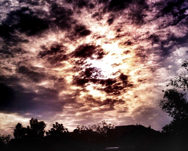 Vista de ángulo bajo del sol brillando a través de las nubes